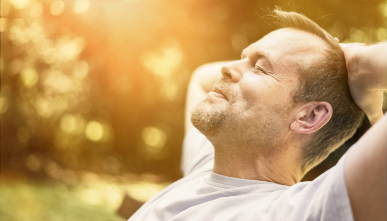 Male relaxing on a bench in the sun